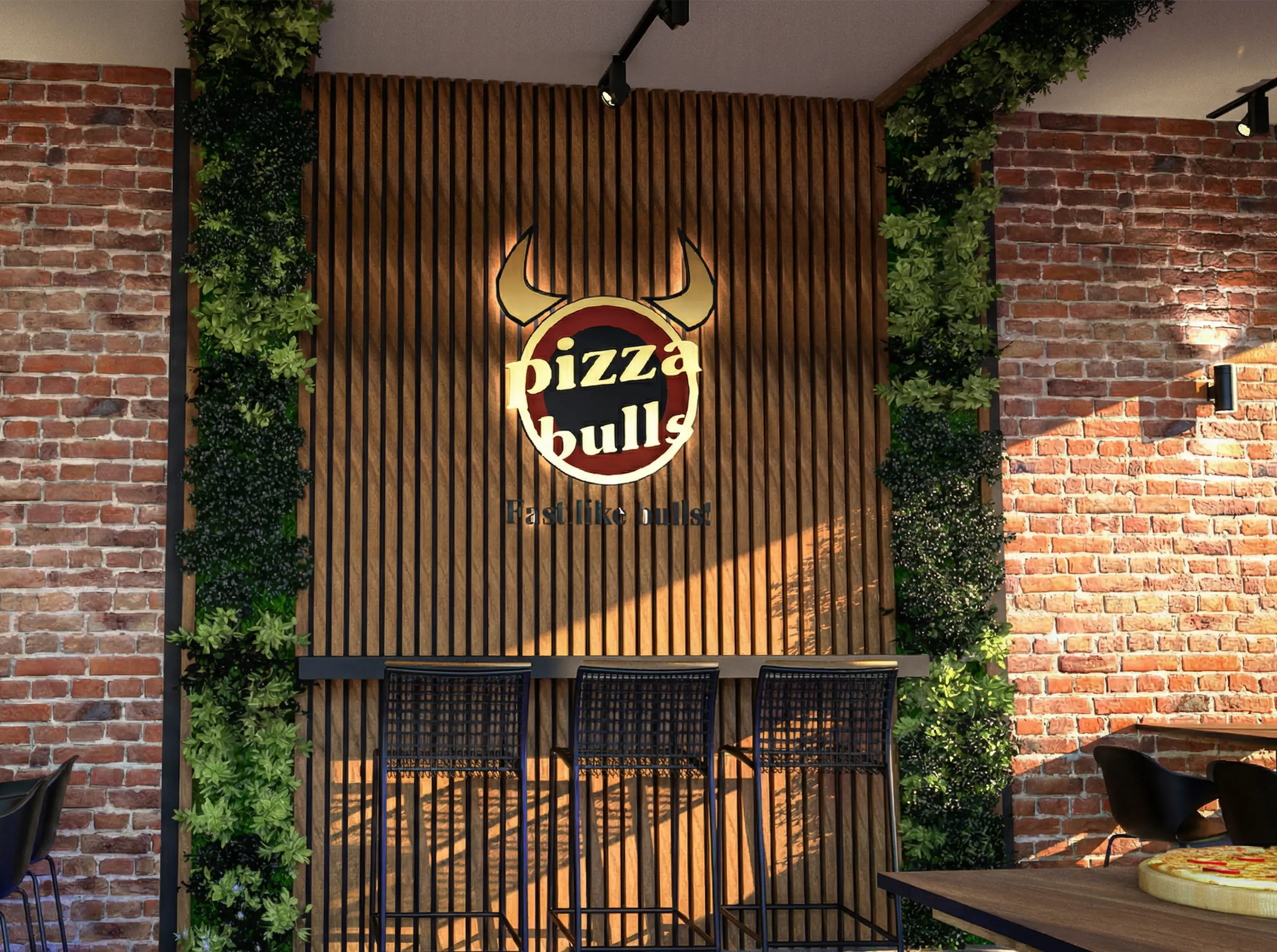 Pizza Bulls Filiale mit Backsteinwand, Holzlamellen und beleuchtetem Logo